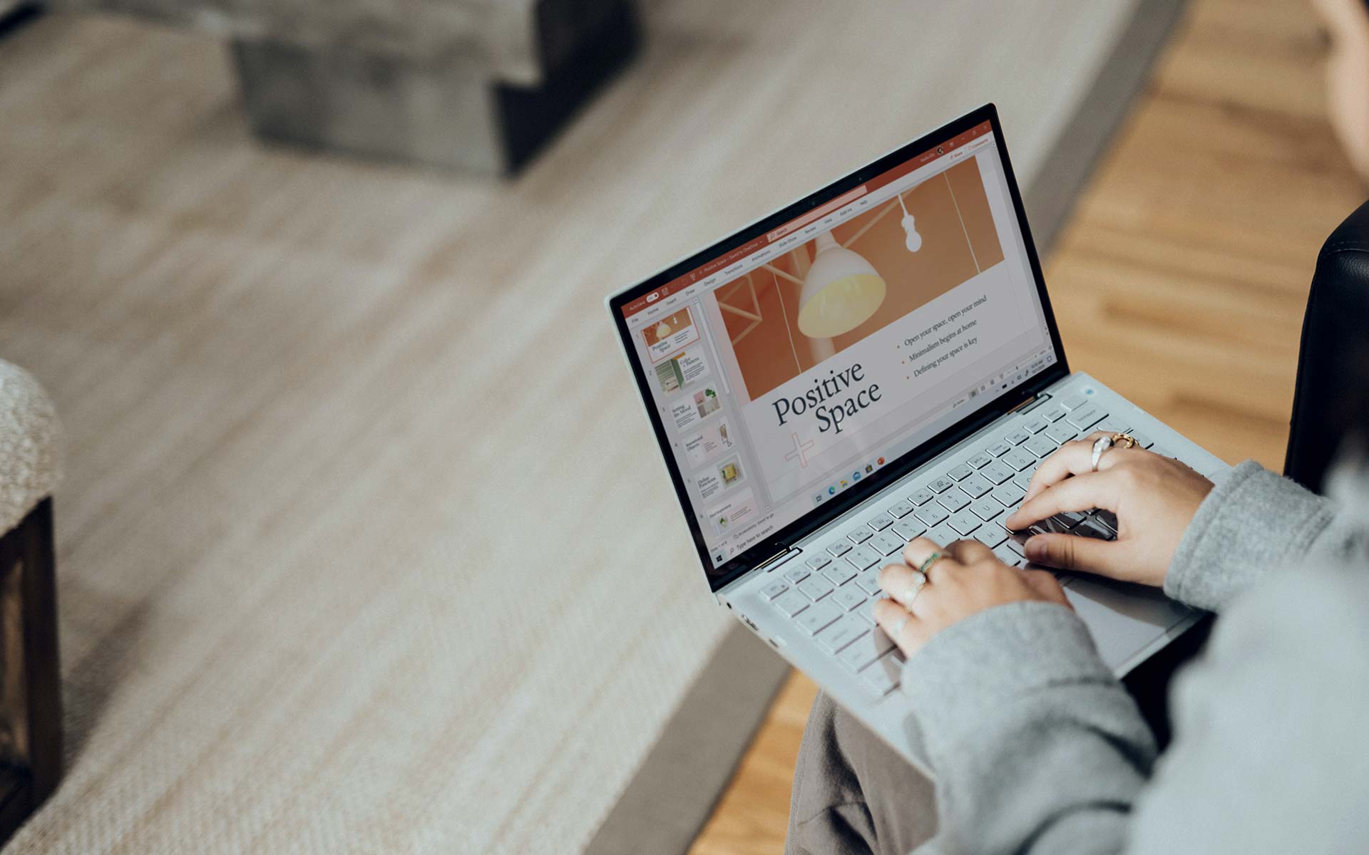 Woman works on the presentation slides on their laptop.